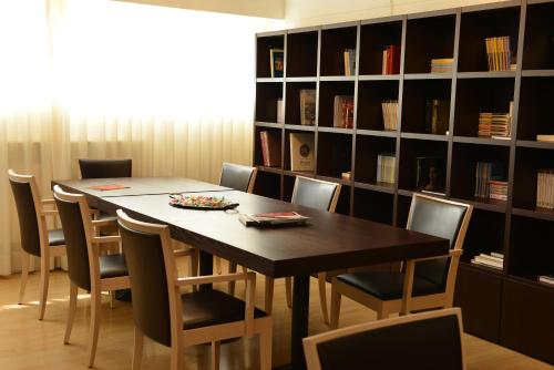 a table and chairs in a room with a book shelf at Albergo Celide in Lucca