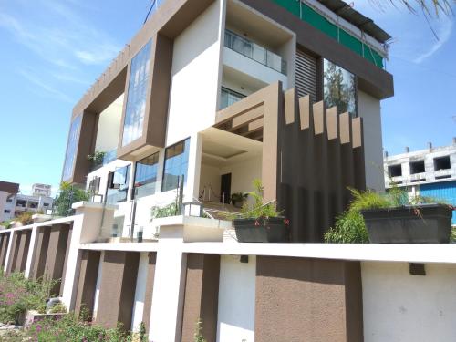 a building with potted plants in front of it at Manasi Pride in Satara