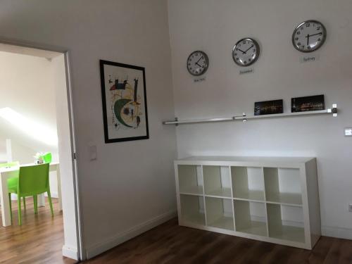 a living room with two clocks on the wall at Studiotel Belle Etage in Düsseldorf