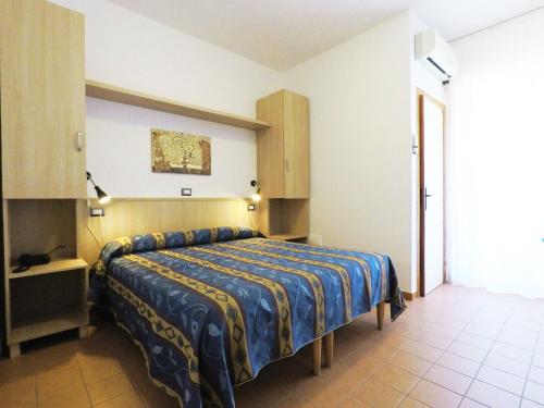 a bedroom with a bed with a blue and yellow blanket at Hotel La Vetta Europa in Castellana Grotte