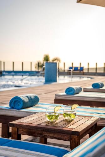 a wooden table with bowls of food on a beach at Casa León Royal Retreat in Maspalomas