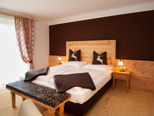 a bedroom with a large bed with black and white pillows at Hotel Krimmlerfälle in Krimml