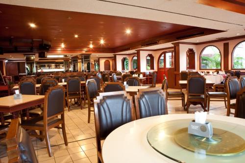 una sala da pranzo con tavoli e sedie in un ristorante di Tanyong Hotel a Narathiwat