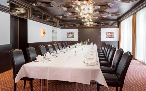 a long dining room with a long table and chairs at Hotel am Kurpark in Bad Hersfeld