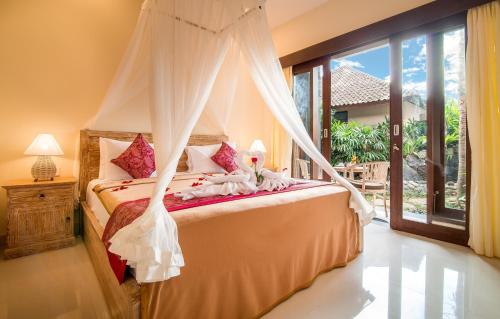Postel nebo postele na pokoji v ubytování Pecatu Ubud Guest House