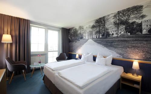 a hotel room with a large bed and a painting on the wall at Hotel Haus Chorin in Chorin