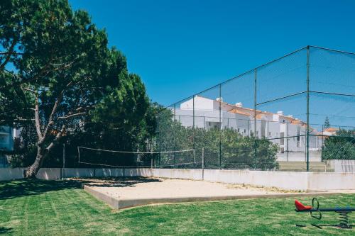 a park with a fence and a bench in front of a building at Grand Muthu Forte Da Oura in Albufeira