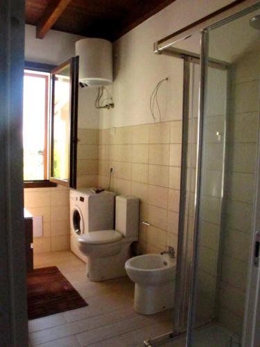 a bathroom with a toilet and a washing machine at Roccabianca in Sorso