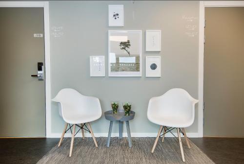 two white chairs and a table in a room at Hotell Eken Mölndal in Mölndal