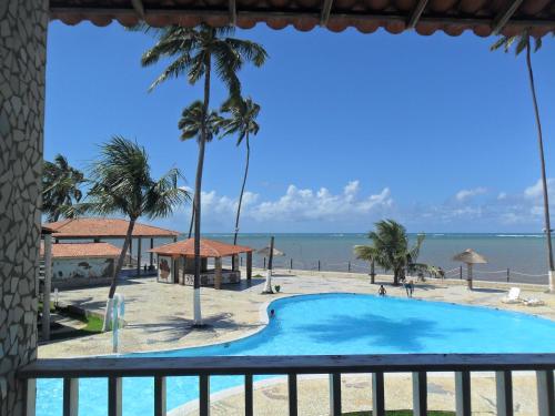 a view of the beach from the balcony of a resort at Flats Privé Village Galés in Maragogi