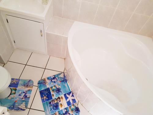 a bathroom with a toilet and a tile floor at Dumela Margate Flat No 3 in Margate
