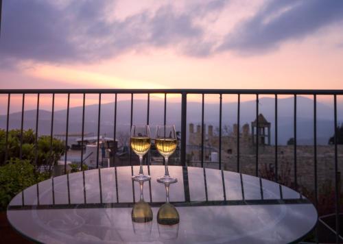 two wine glasses sitting on a table on a balcony at Artists' Colony Inn Zefat in Safed