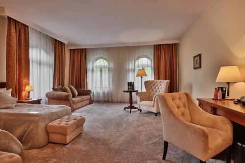 a hotel room with a bed and a desk and chairs at Grand Hotel Stamary in Zakopane