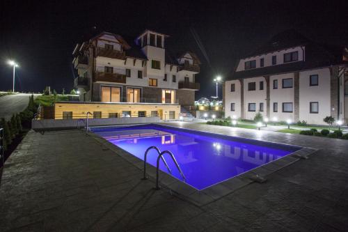 a swimming pool in front of a building at night at Zlatibor Hills in Zlatibor