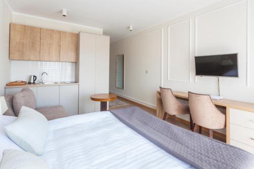 a bedroom with a bed and a desk and a kitchen at Zlatibor Hills in Zlatibor