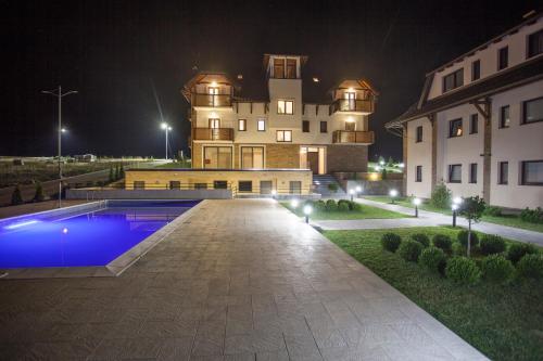 a large building with a pool in front of it at night at Zlatibor Hills in Zlatibor