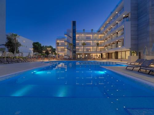 a swimming pool in front of a building at night at H10 Casa del Mar in Santa Ponsa