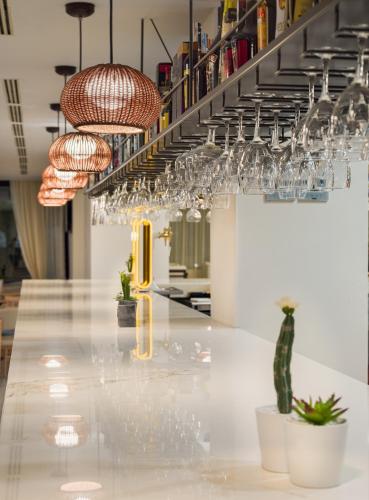a bar with wine glasses hanging above a counter at H10 Casa del Mar in Santa Ponsa