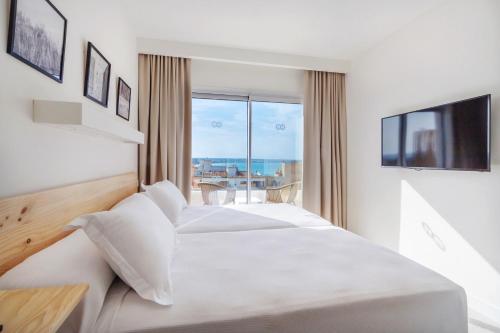 une chambre d'hôtel avec un lit et une télévision dans l'établissement HM Alma Beach - Adults Only, à Can Pastilla