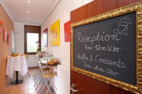 a chalkboard sign in a restaurant with a table at Michaelis Hof in Hamburg