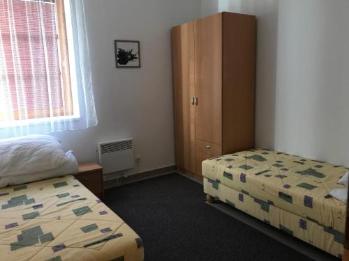 1 dormitorio con 2 camas, armario y ventana en Pohoda v Říčkách, en Říčky