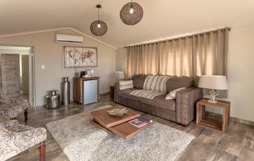 un soggiorno con un divano e un tavolo di Sossusvlei Lodge a Sesriem