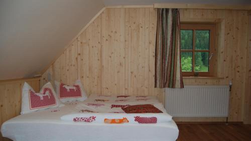 a bedroom with a large white bed with a window at Ferienhof Karin und Florian Gressenbauer in Edlbach