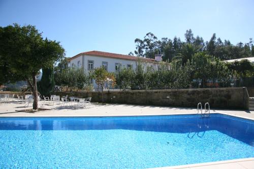 a large swimming pool in a residential area at Hotel Quinta Progresso in Macieira de Cambra