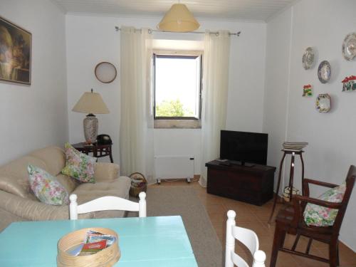 a living room with a couch and a table at Casa Do Avô In Montejunto in Cadaval