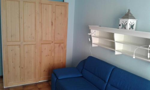 ein blaues Sofa in einem Zimmer mit Holztür in der Unterkunft casa vacanze Martinsicuro in Martinsicuro