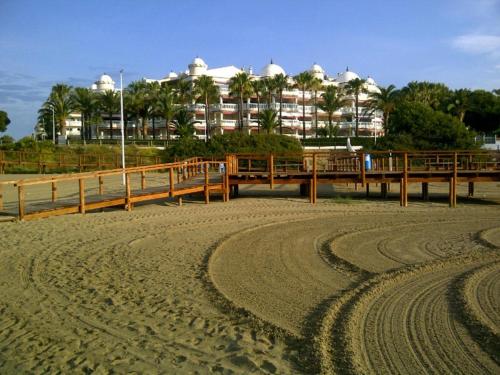 a beach with a pier and a building in the background at Apartment Martinez Casablanca in Alcossebre