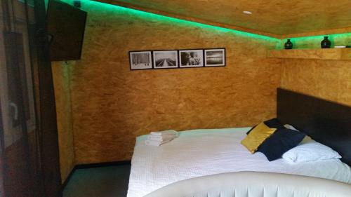 Cabane Zen في كورباي إيسون: غرفة نوم بسرير بثلاث صور على الحائط