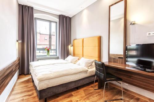 a hotel room with a bed and a desk at Grand Boutique Hotel - dawny Hotel Kaliski Ratuszowy in Rzepin