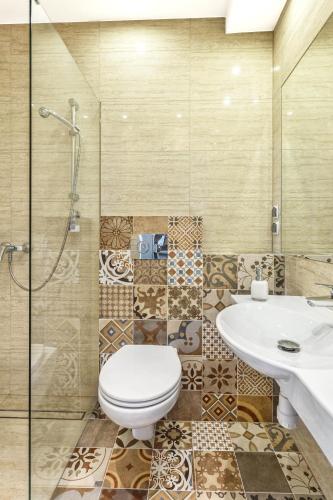 a bathroom with a toilet and a sink and a shower at Grand Boutique Hotel - dawny Hotel Kaliski Ratuszowy in Rzepin
