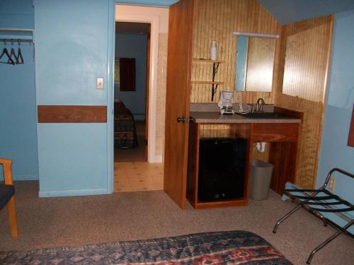 Habitación con cocina con encimera y mesa. en Mohican Motel, en Cooperstown