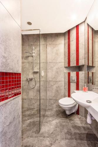 a bathroom with a shower and a toilet and a sink at Grand Boutique Hotel - dawny Hotel Kaliski Ratuszowy in Rzepin