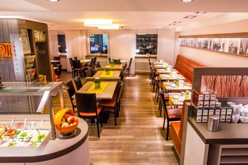 un restaurant avec des tables et des chaises et une cafétéria dans l'établissement Hotel Martinihof, à Münster