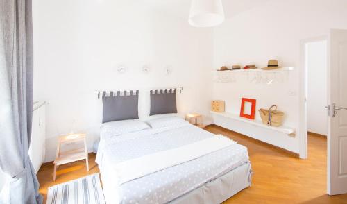 - une chambre blanche avec un grand lit blanc dans l'établissement BIBA casa vacanze, à Omegna
