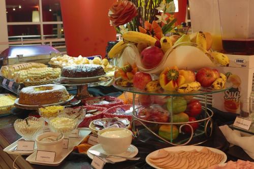 a buffet of fruit and cakes on a table at Favorita Golden Hotel e Eventos in São José