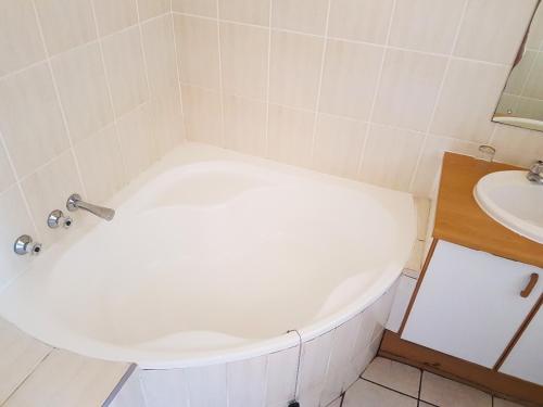 a white bath tub in a bathroom with a sink at Dumela Margate Flat No 2 in Margate