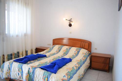 a bedroom with a bed with blue pillows on it at Thea Studios in Kalamakia