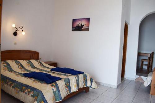 a bedroom with a bed with blue pillows on it at Thea Studios in Kalamakia