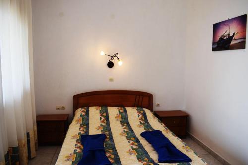 a bedroom with a bed with blue pillows on it at Thea Studios in Kalamakia