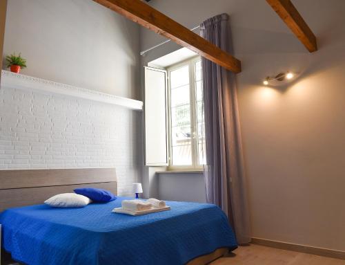 ein Schlafzimmer mit einem blauen Bett und einem Fenster in der Unterkunft Famigi in Neapel