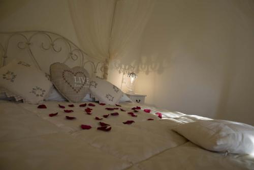 a white bed with hearts and roses on it at La Dolce Casetta in Grottaferrata