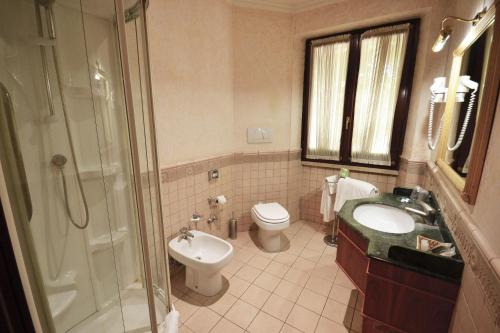 e bagno con servizi igienici, lavandino e doccia. di Hotel Cilicia a Roma