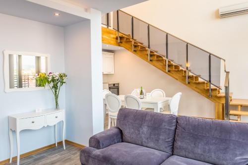 a living room with a purple couch and a staircase at Galeon Residence & SPA in Sunny Beach