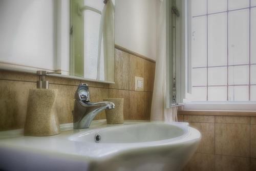 lavabo con grifo y espejo en La Dolce Casetta, en Grottaferrata