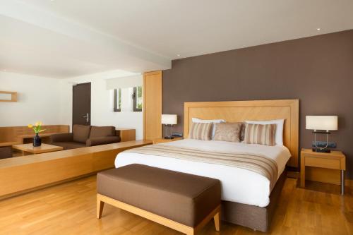 a bedroom with a large bed and a couch at Wyndham Loutraki Poseidon Resort in Loutraki