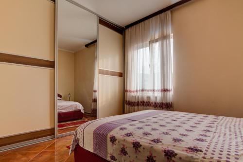 ein Schlafzimmer mit einem Bett und einem großen Spiegel in der Unterkunft Residence Lamba in Radanovići